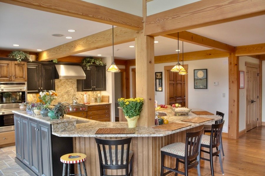 A wide, open country kitchen with an island and medium brown tones.
