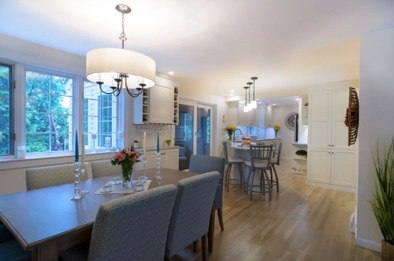 This gorgeous white kitchen features floor-to-ceiling cabinets, a wine rack and a peninsula that seats 3.